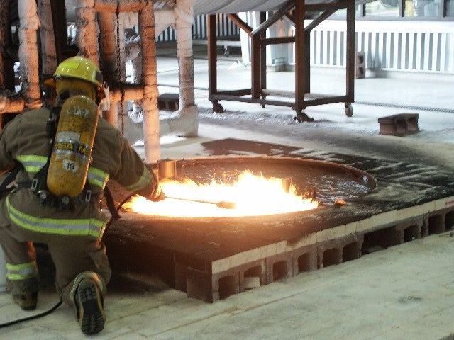 Firefighter lighting JP8 "spill" fire.