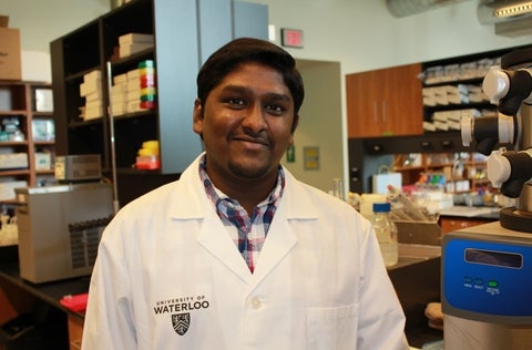 Lokesh Narsineni wearing lab coat in lab