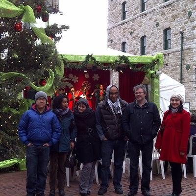 Foldvari lab group members standing infront of large Christmas tree and stage.