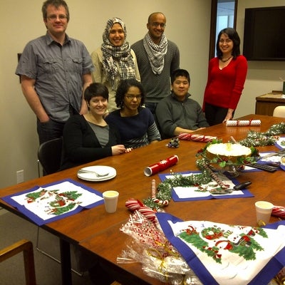 Foldvari lab group members sitting around table decorated for Christmas.