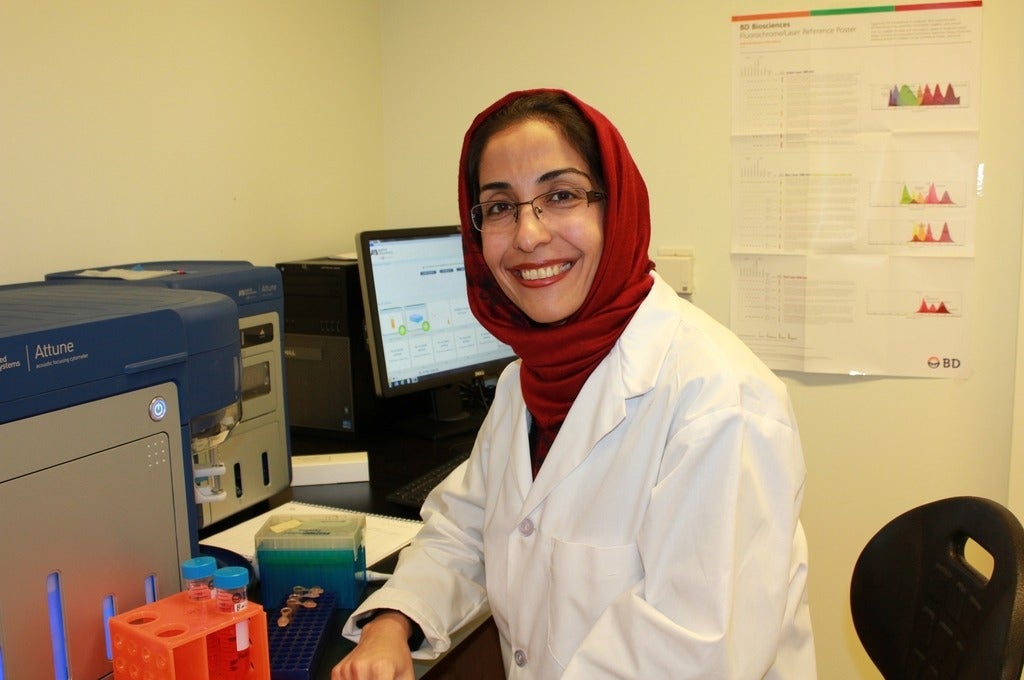 Maran Gharagozloo in labcoat at flow cytometer