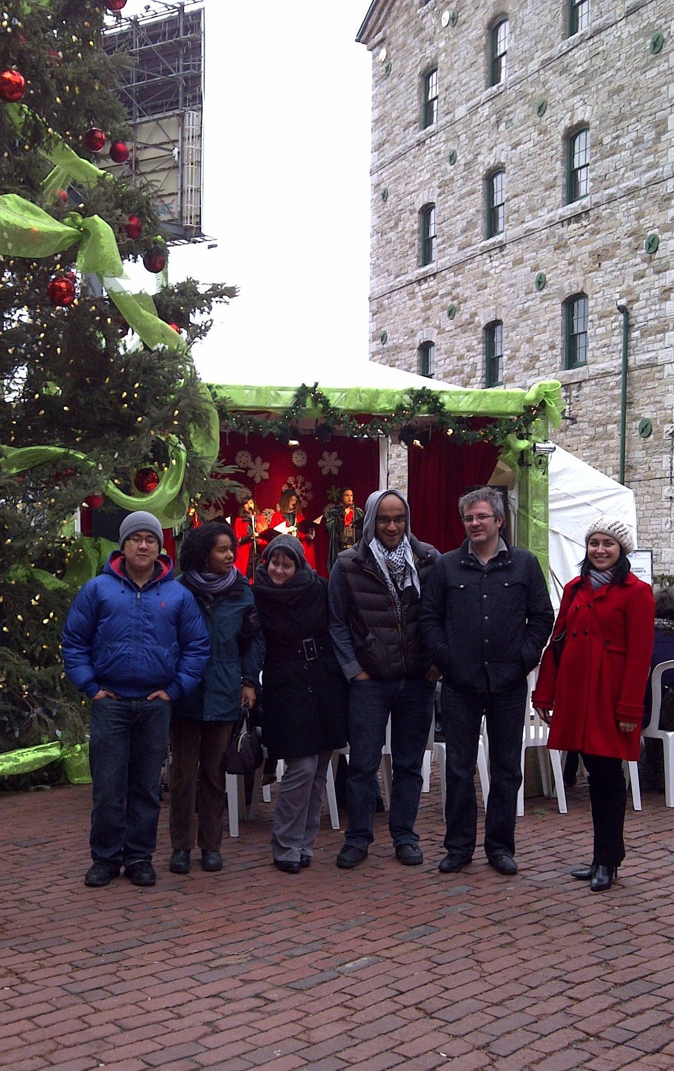 Foldvari lab group members standing infront of large Christmas tree and stage.
