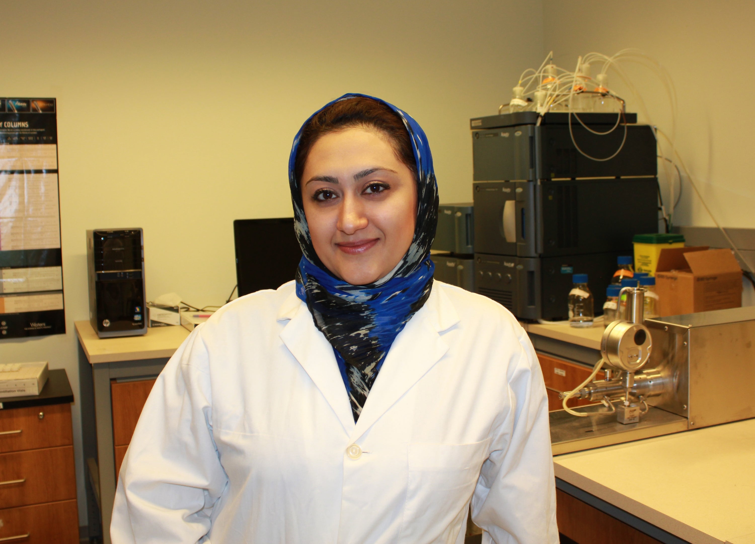 Nafiseh Nafissi wearing lab coat infront of UPLC
