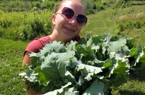 Person holding leafy vegetables 