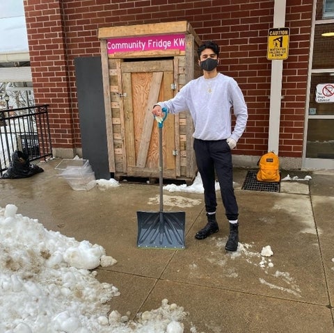 Kamil Ahmed, founder, standing in front of the KW Community Fridge