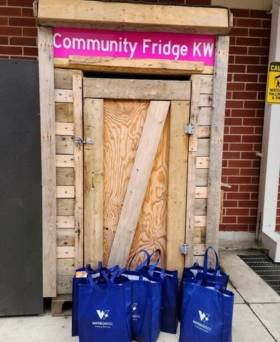 The Community Fridge KW with blue bags outside the door
