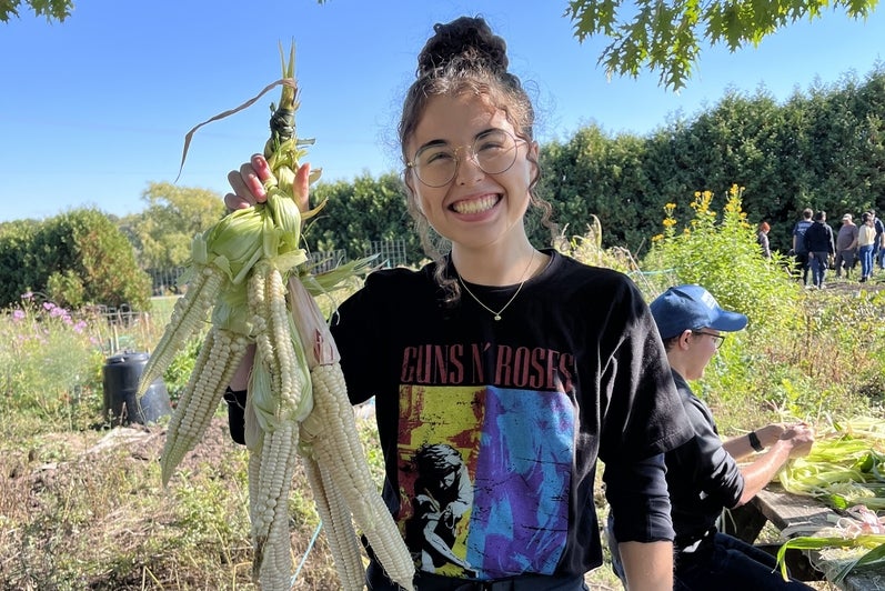 Student holding corn they tried to braid at Wisahkotewinowak Indigenous Produce Garden