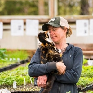 Angie Koch, farm manager of Fertile Ground farm, holding a cat at the farm