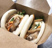 two bao in a brown take out box