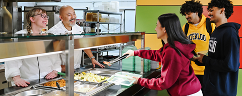 Students taking food from hot table