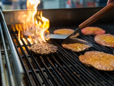 burger patties on a grill with fire