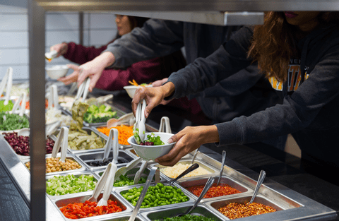 Students taking food from salad bar