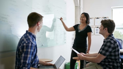 a woman in front of a whiteboard teaching