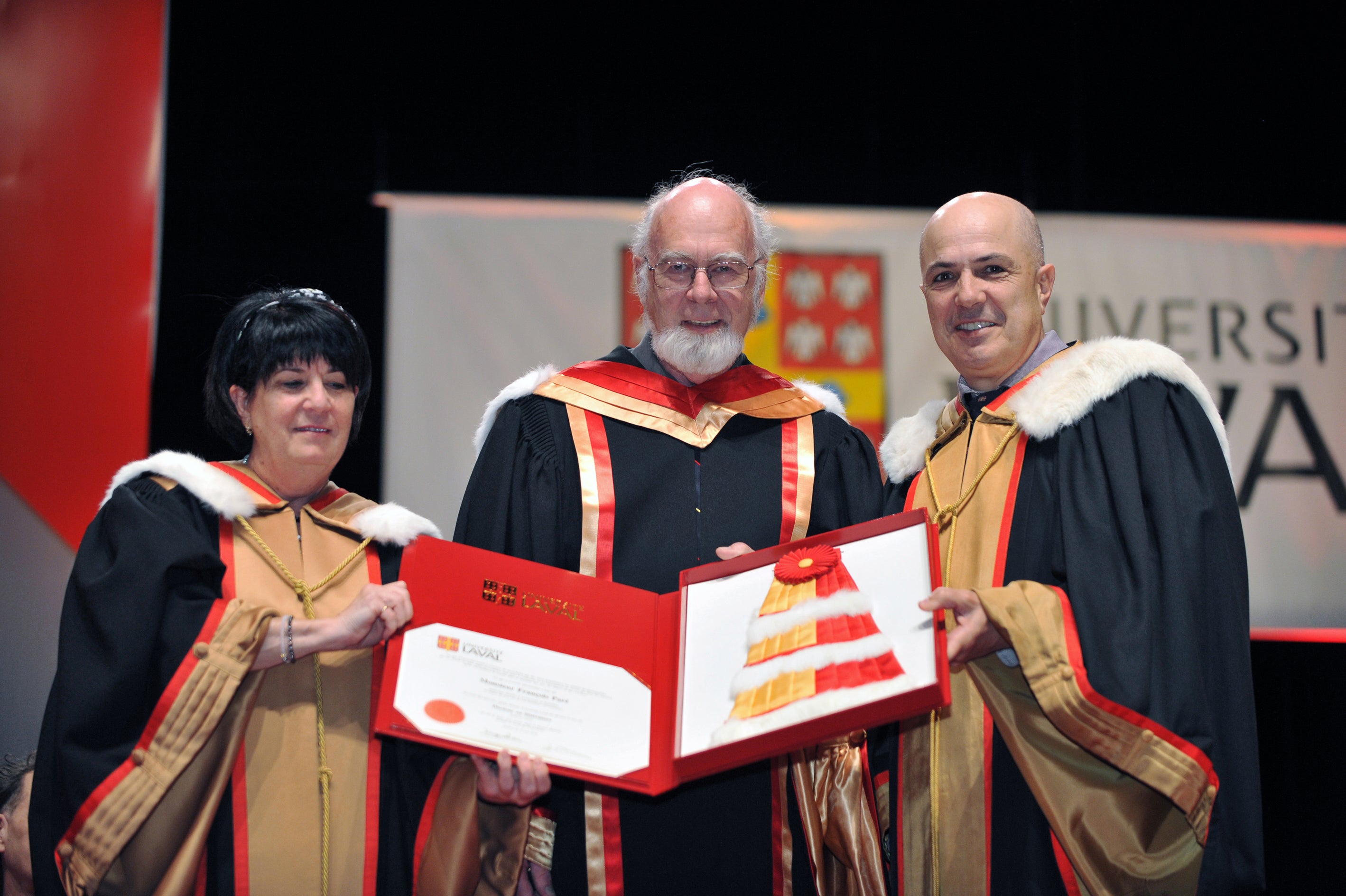 Francois Pare and two members of Laval in academic robes holding doctorate