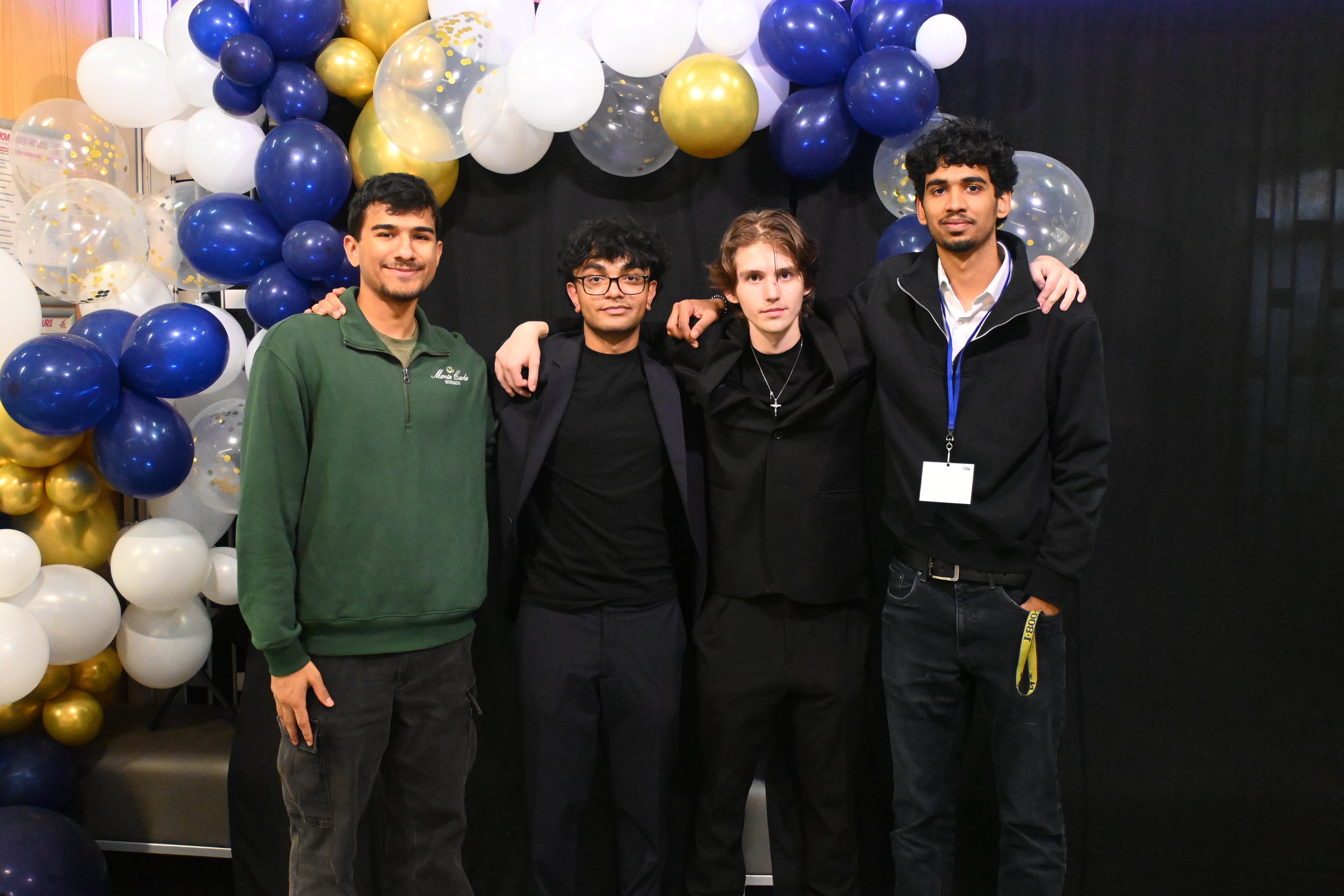 student smiling in front of balloon arch