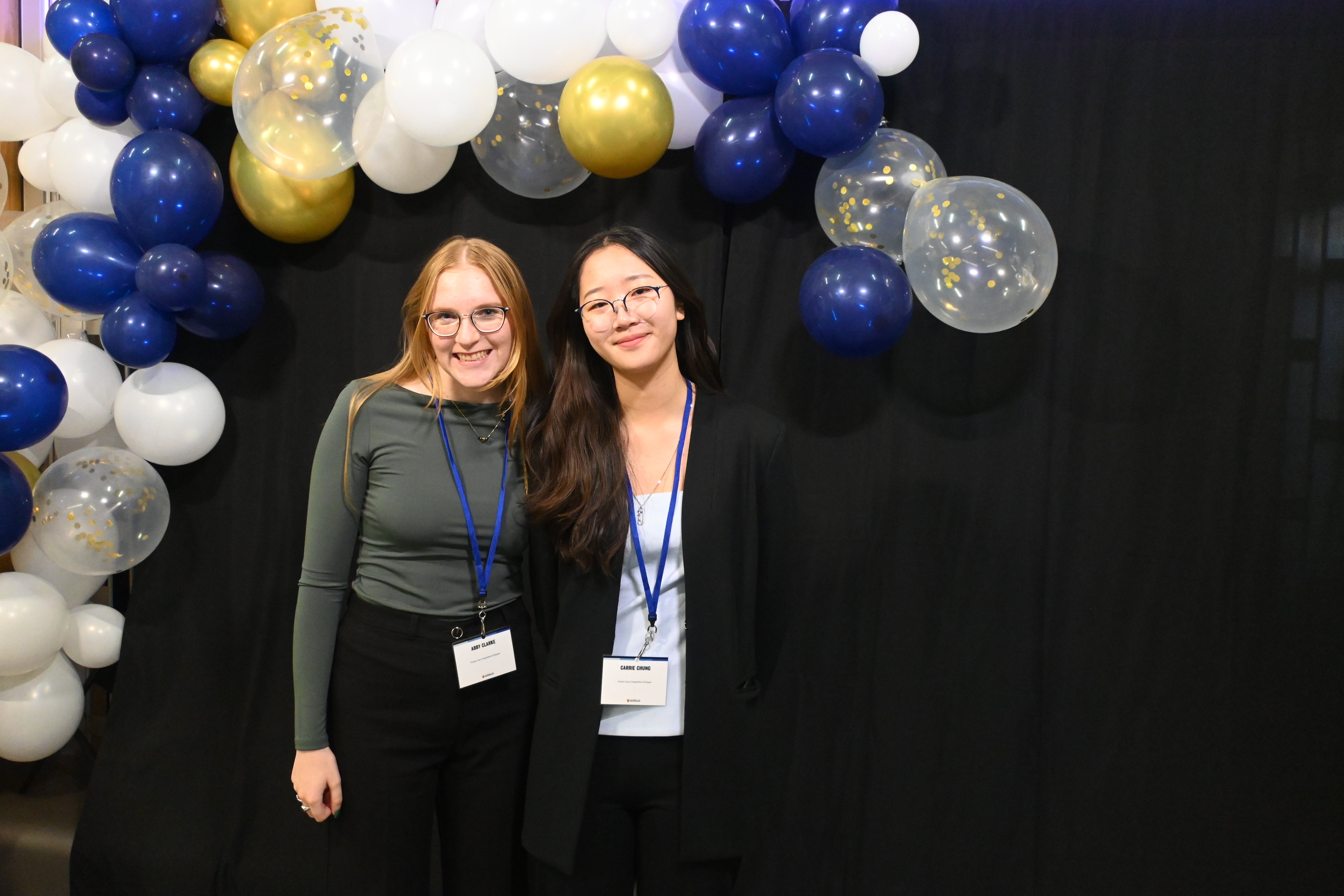 Students posing in front of balloon arch