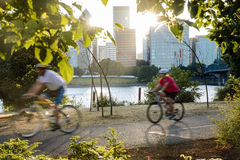 People biking on a trail in the city.