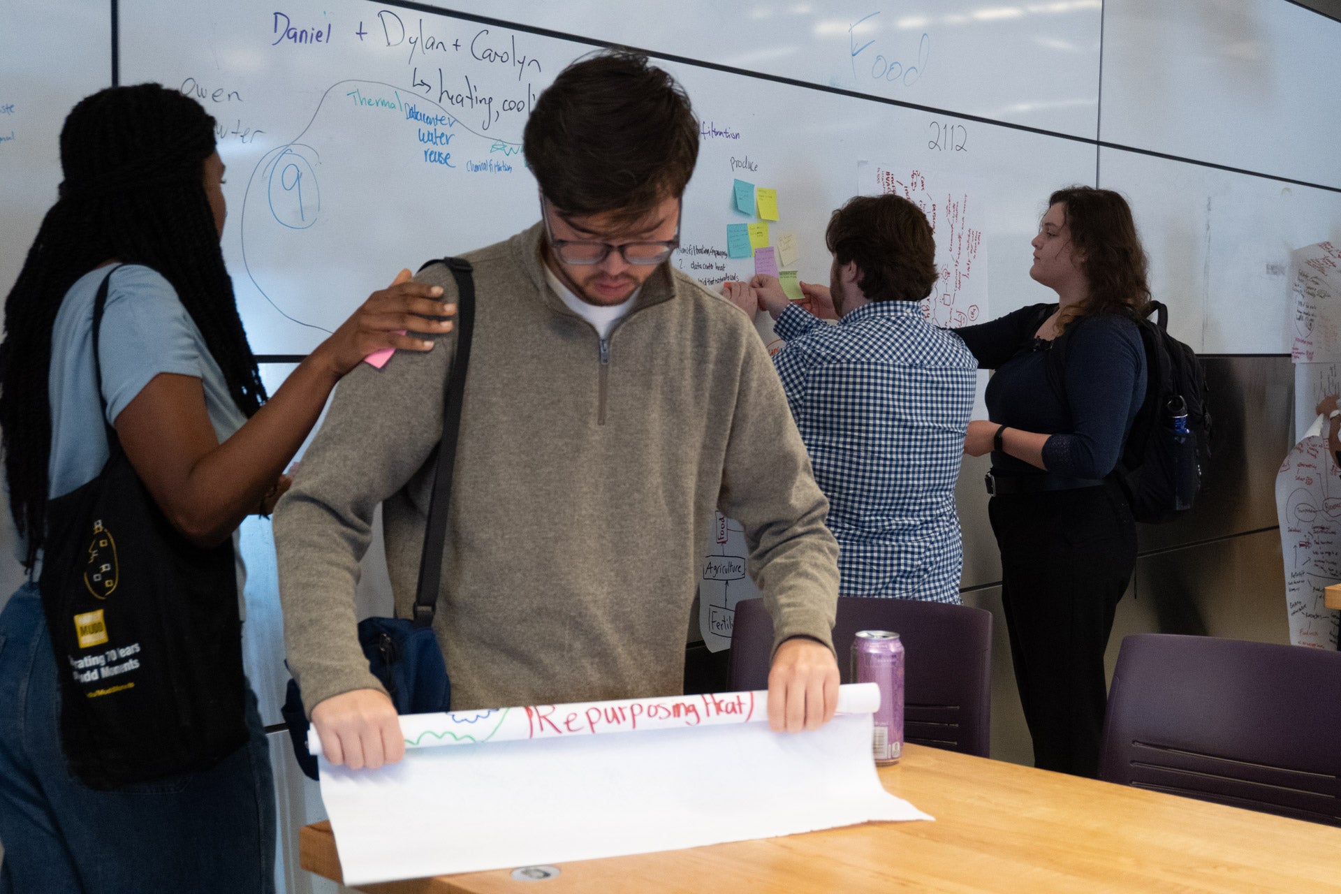 a student sticks a sticky note on a fellow presenter