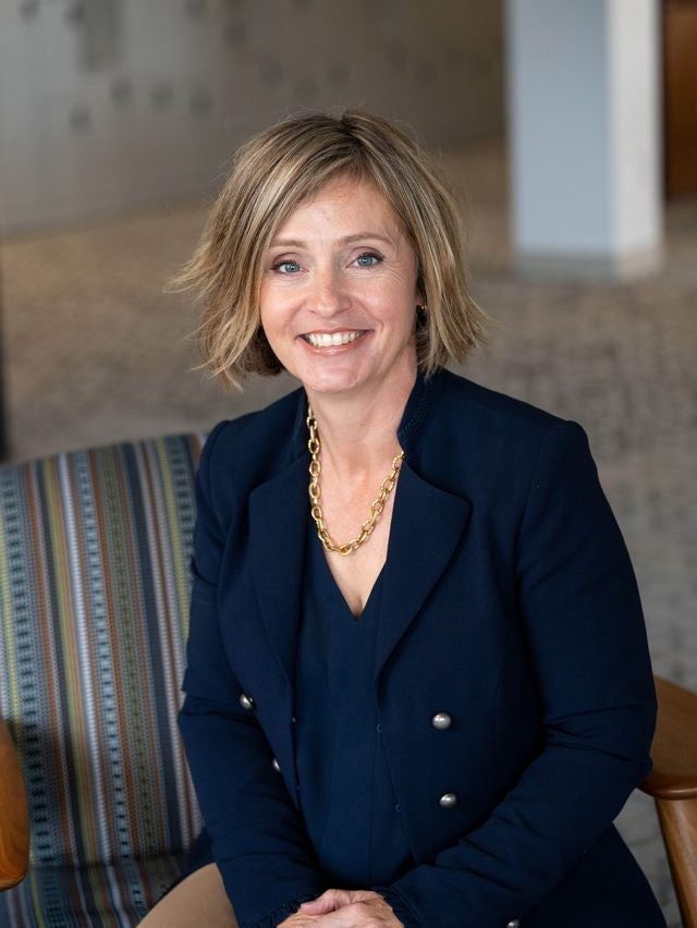 Kelly McManus Headshot Photo sitting in chair