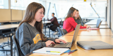 A student works at a laptop