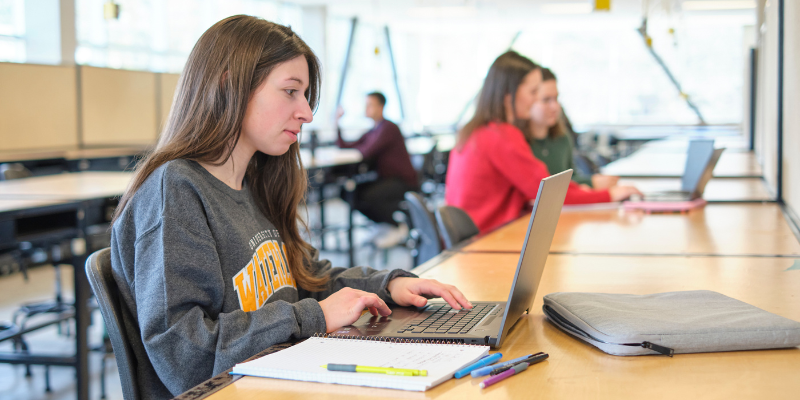 A student works on a laptop at a table