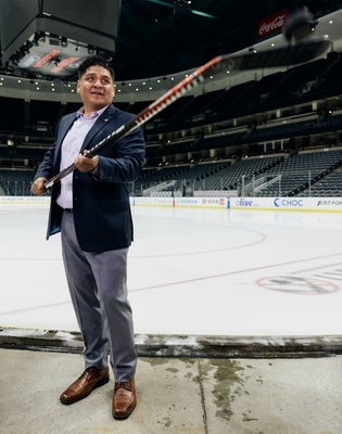 Joe Villanueva holding a hockey stick.