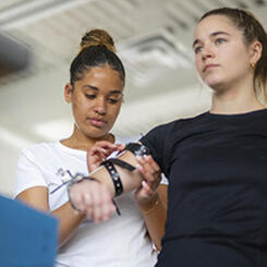Health student measuring another student's arm for an arm prototype