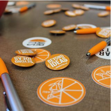 orange arts stickers and pins scattered on a table