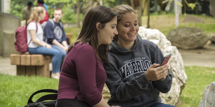 2 students looking at a cell phone.