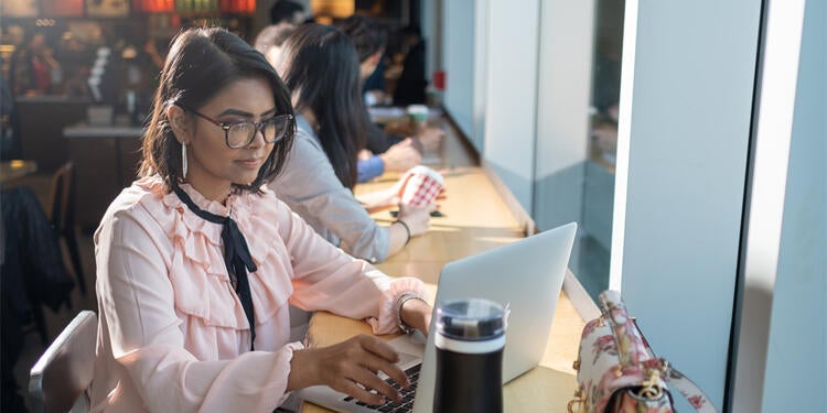 Female student using her laptop at a coffee shop.