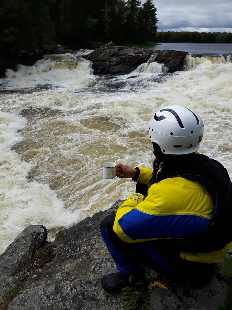 Vincent having a coffee alongside whitewater rapids.