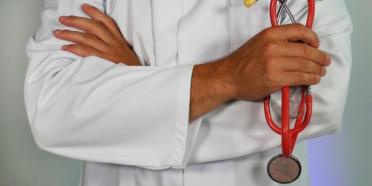 A person in a doctor coat, with a stethoscope.