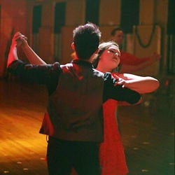 Two students dancing arm in arm