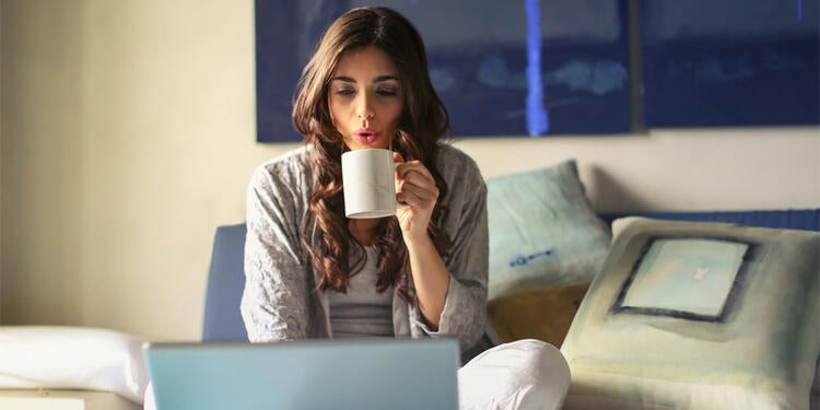 Girl drinking coffee in bed.