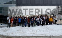 Engineering students standing in front of a Waterloo sign