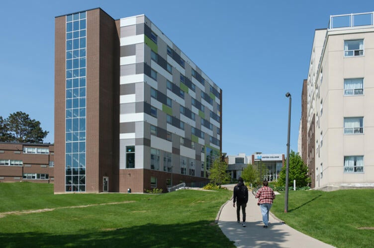 2 students walking toward a residence building