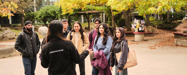 A group of students listening to a student ambassador