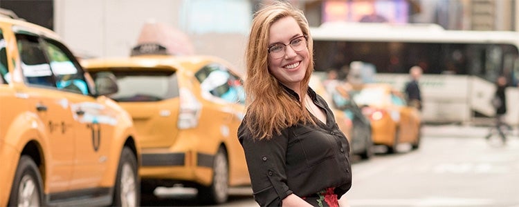 Female student in New York City with taxis in background