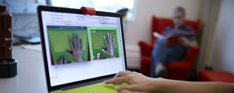 A computer science student uses a laptop to learn about human-computer action.