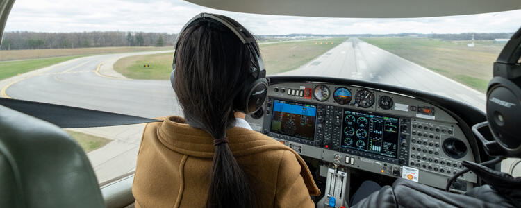 A student pilot in Waterloo's aviation program leans forward as she prepares to land on a runway