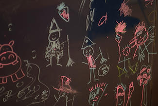 Children's drawings on a chalkboard.
