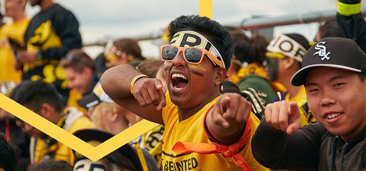 student wearing gold and black cheering
