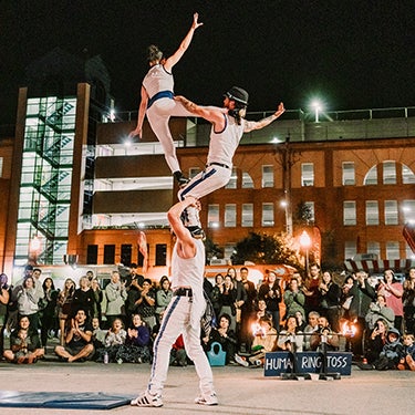 People performing acrobatics in Uptown Waterloo at night 