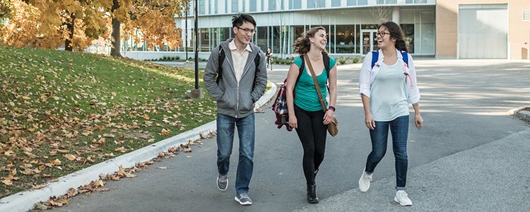 Three students walking on University of Waterloo campus.