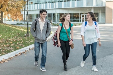 Three students walking across University of Waterloo campus