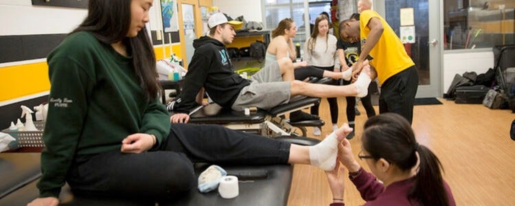 Waterloo Kinesiology students practise foot and ankle taping.