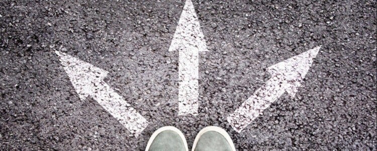 Feet standing in front of arrows pointing 3 directions.