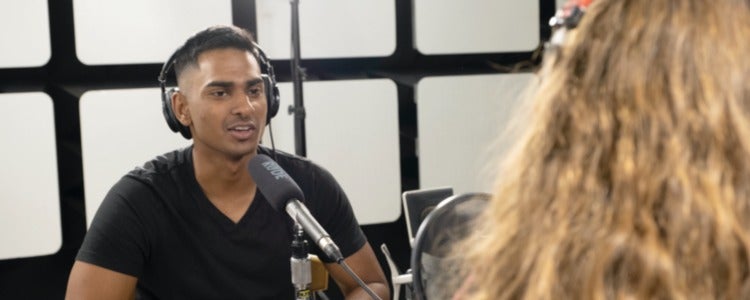 Ashoke, sitting in studio, interviewing a guest for his podcast