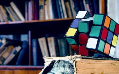A rubiks cube on a book.