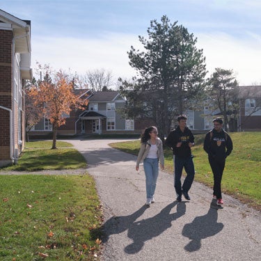 Three students walking outside of the Columbia Lake Village townhouses